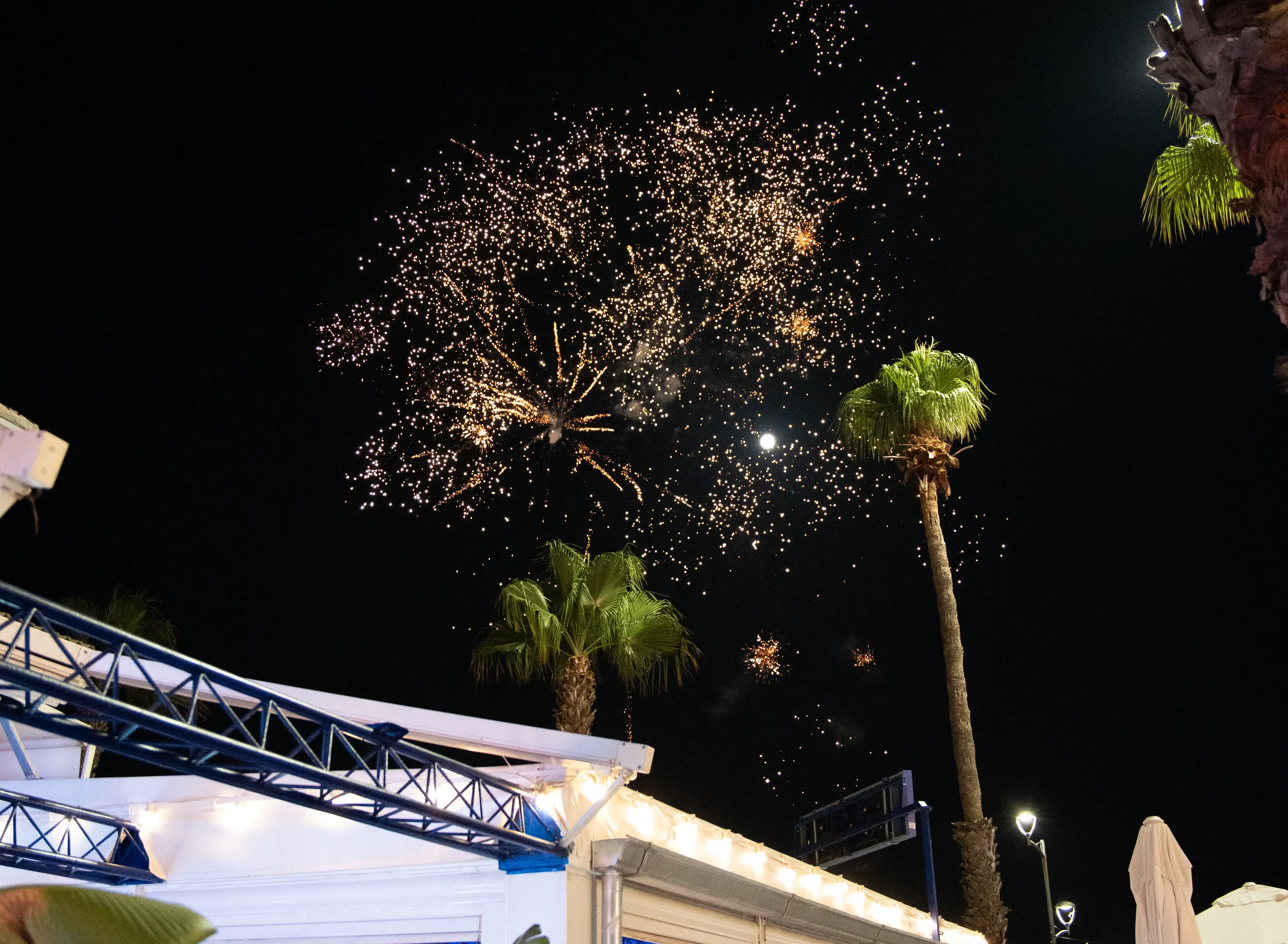 Di notte, i fuochi d'artificio sopra il Sixteen, fra le palme